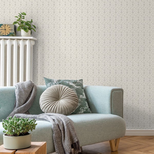 Wohnzimmer mit Couch, Kissen und gemusterter Tapete