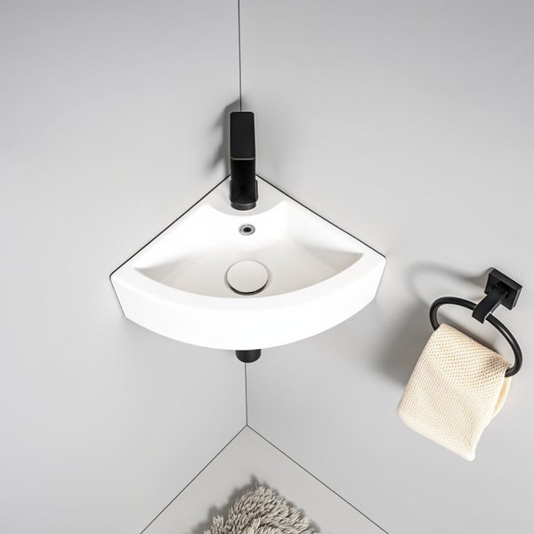 Eckwaschbecken aus Keramik mit Armatur und Handtuchhalter an einer Wand montiert für kleine Badezimmer oder Gästetoiletten