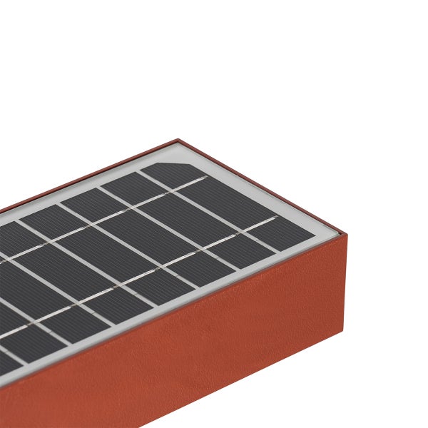 Detailaufnahme eines integrierten Solarmoduls auf einer rechteckigen, rostfarbenen Außenleuchte.