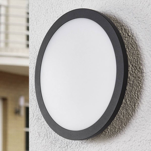 Runde LED-Außenwandleuchte mit anthrazitfarbenem Rahmen und weißem Diffusor, an einer Wand montiert.