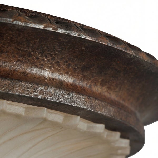 Detailaufnahme einer Deckenleuchte mit Metalleinfassung und Lampenschirm aus Glas