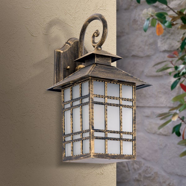 Rustikale Außenwandleuchte in Laternenform aus Metall mit Patina-Optik und satiniertem Glas an einer Hauswand.