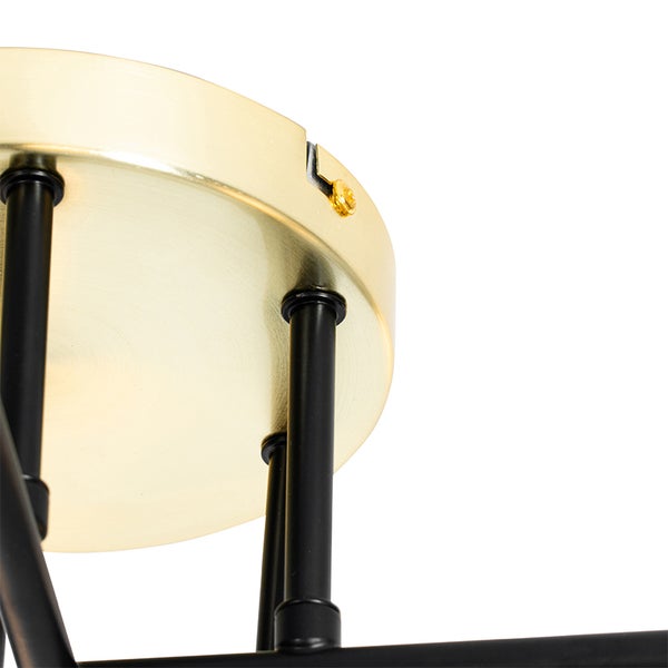 Detailansicht einer Deckenleuchte mit goldfarbener Deckenbefestigung und schwarzen Streben