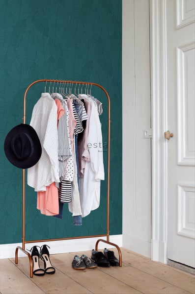 Ein Zimmer mit einer Garderobe, Kleidung, Schuhen und einer Tapete mit Blattmuster