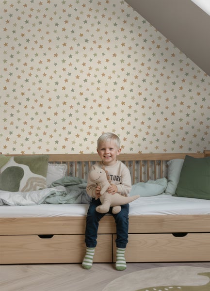 Kinderzimmer mit Vliestapete im Sternmuster, Holzbett mit Bettkasten und hellem Holzboden.