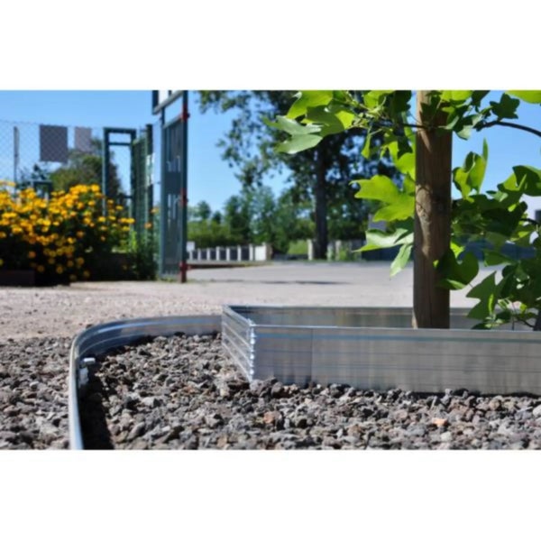 Biegsame Rasenkante aus Metall zur Einfassung eines Baumes in einem mit Kies gestalteten Garten.
