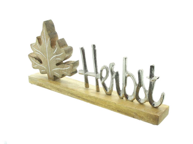 Herbstdekoration mit hölzernem Blatt und silberfarbenem Schriftzug Herbst auf Holzsockel