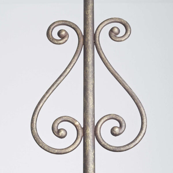 Dekoratives Element mit geschwungenen Ornamenten auf Metallstange