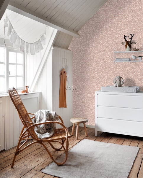 Helles Kinderzimmer mit Rattansessel, Wickelkommode und gemusterter Tapete