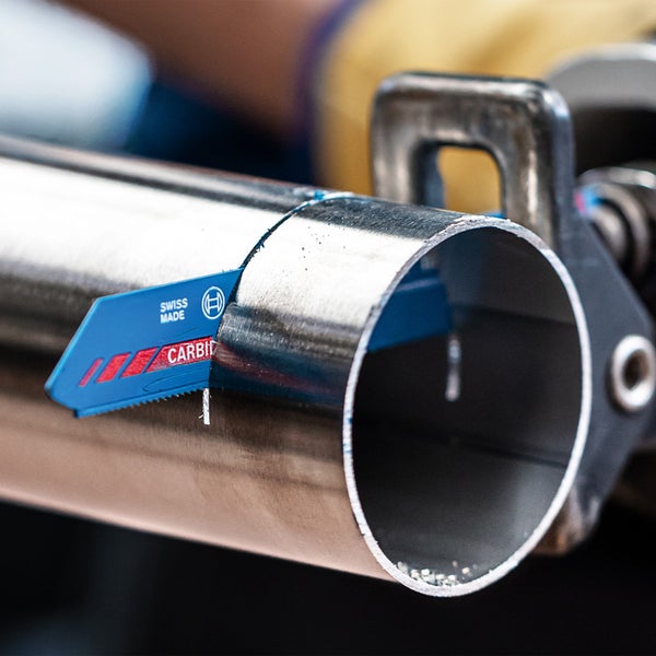 Nahaufnahme eines Metallsägeblatts beim Schneiden eines Metallrohrs