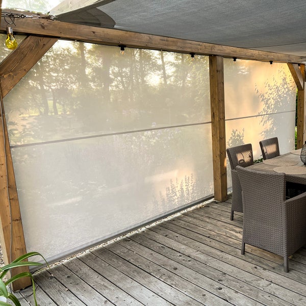Sichtschutz und Sonnenschutz für den Außenbereich, montiert an einer Holzpergola auf einer Terrasse mit Holzdeck und Gartenmöbeln.