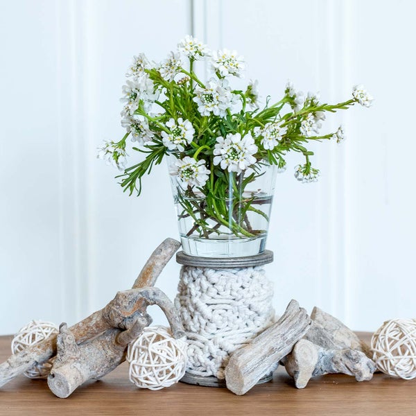 Stillleben mit Blumen in Vase, Holzelementen und Dekokugeln