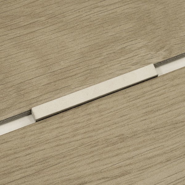 Fliesenabstandshalter zwischen zwei Holzoptikfliesen auf einem Fliesenboden