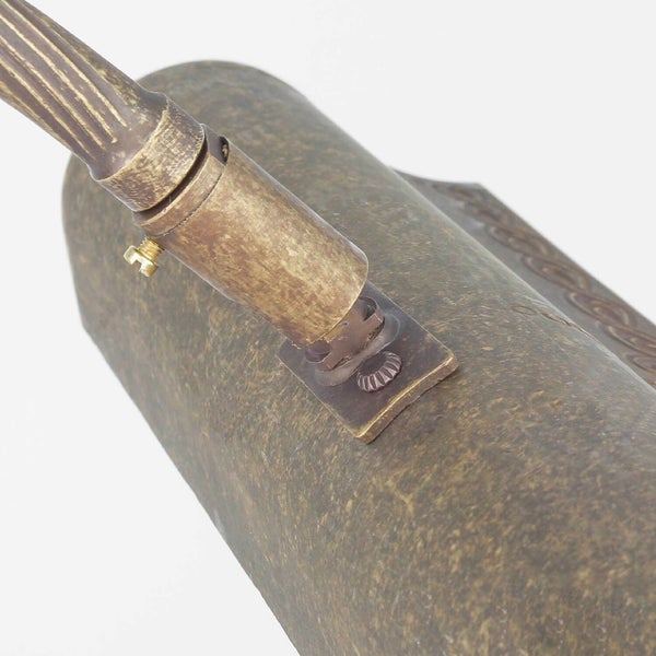 Nahaufnahme einer bronzefarbenen Leuchte mit einem verstellbaren Arm