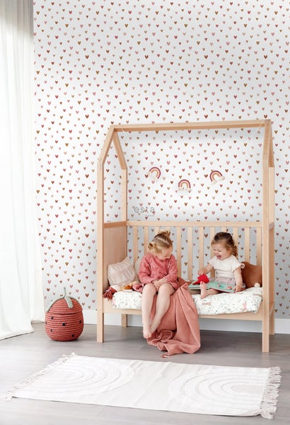 Kinderzimmer mit Bett im Hausdesign, Tapete mit Herzmuster und zwei kleinen Mädchen.