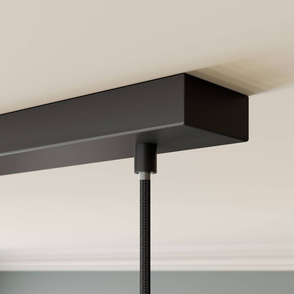 Schwarzer rechteckiger Deckenbaldachin einer Leuchte mit schwarzem Textilkabel.