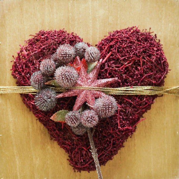 Dekoratives Herz aus Zweigen mit Stern- und Kugelverzierungen