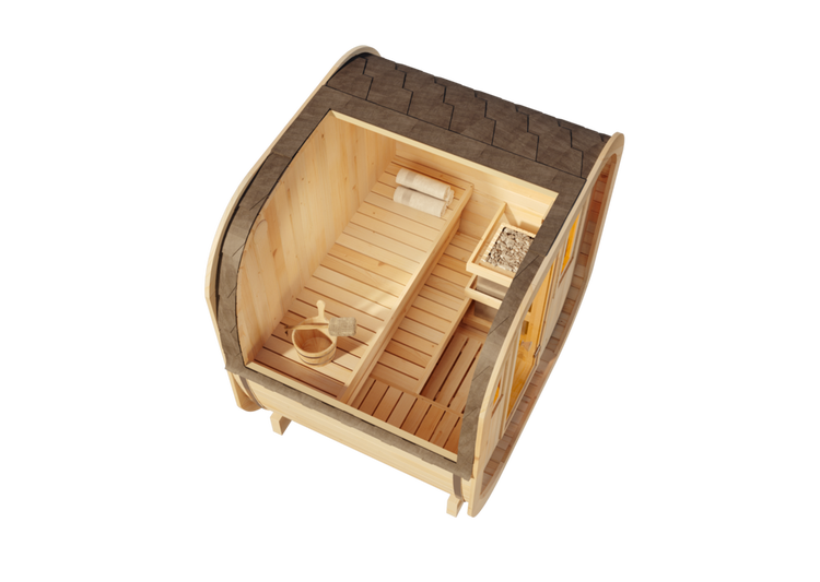 Innenansicht einer Fasssauna aus hellem Holz mit zwei Bänken einem Saunaofen mit Steinen einem Aufgusskübel und Handtüchern.