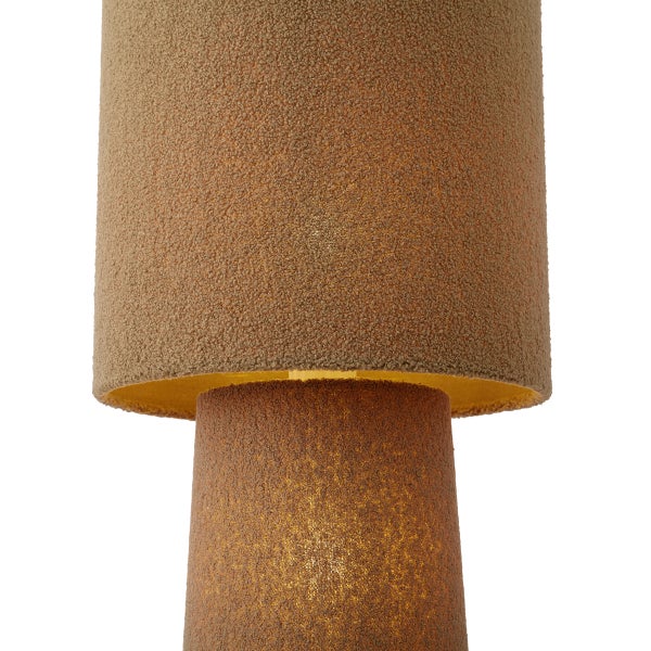 Tischleuchte mit Lampenschirm und Fuß aus strukturiertem Stoff, eingeschaltet mit warmem Licht.