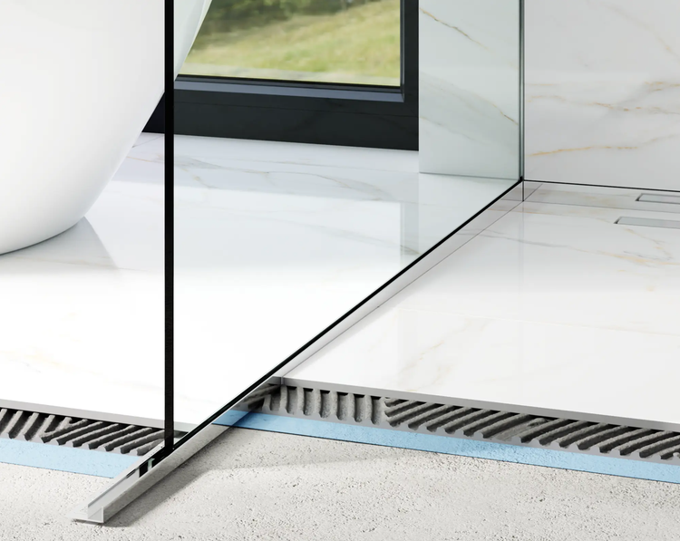 Detailansicht einer bodengleichen Dusche mit Glaswand und Metalleinfassung auf Fliesen in Marmoroptik mit sichtbarem Bodenaufbau.