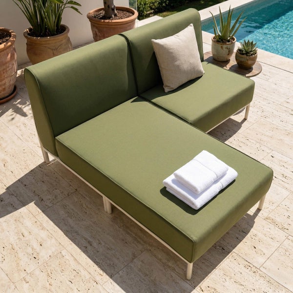 Moderne grüne Garten-Lounge mit weißem Gestell auf einer Steinterrasse am Pool, bestehend aus zwei Elementen mit grünen Polstern und Kissen.