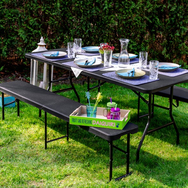 Esstischgarnitur mit Tisch, Bänken, Geschirr und Getränken im Garten