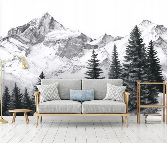 Fototapete mit einer schwarz-weißen Illustration von Bergen und Tannenbäumen hinter einem grauen Sofa in einem hellen Wohnzimmer.