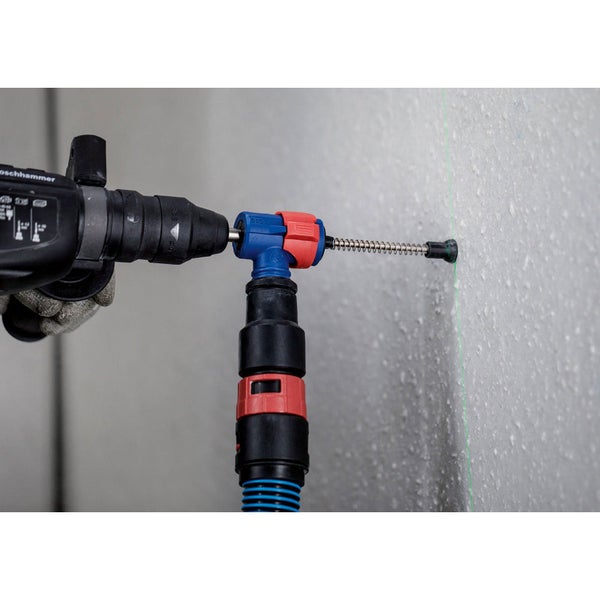 Bohrmaschine mit Bohrstaubabsaugung beim Bohren in eine Wand