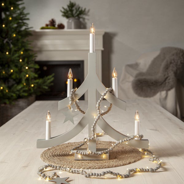 Dekorativer grauer Weihnachtsbaum aus Holz mit fünf elektrischen Kerzen, Sternen und Lichterkette auf einem Tisch