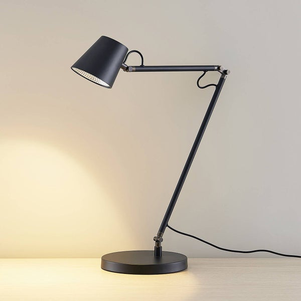 Schwarze Schreibtischlampe aus Metall mit verstellbarem Gelenkarm, rundem Standfuß und konischem Schirm auf einer Holzoberfläche.