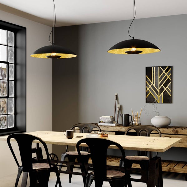 Esszimmer im Industriedesign mit zwei schwarzen Pendelleuchten mit goldener Innenseite über einem Holztisch und schwarzen Metallstühlen.