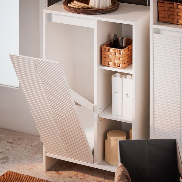 Weißer Badezimmerschrank mit offener Wäscheklappe und Regalen zur Aufbewahrung von Badutensilien