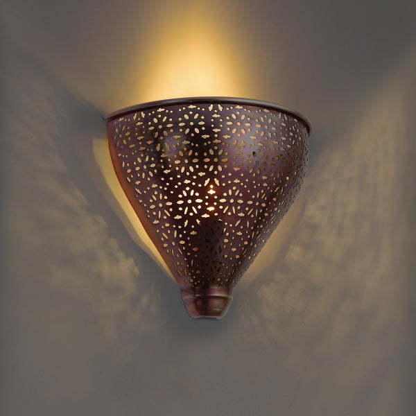 Wandleuchte in orientalischer Optik mit Lochmuster und warmem Lichtschein an einer Wand
