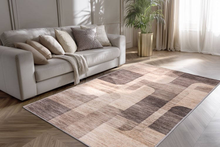 Wohnzimmer mit Sofa, Kissen und modernem Teppich mit abstraktem Muster auf Fischgrätparkett.