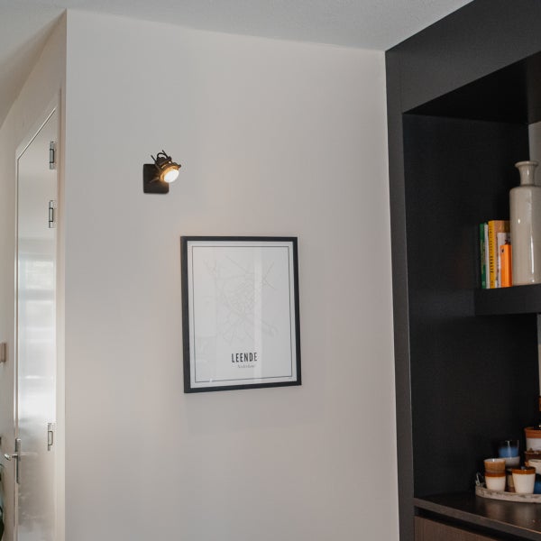 Wand mit Karte, Regal und einer Wandleuchte