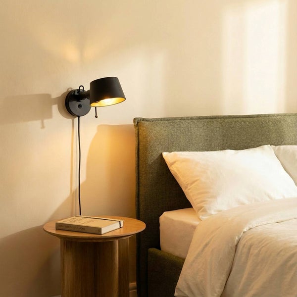 Schlafzimmer-Szene mit Nachttisch, Buch und Wandleuchte