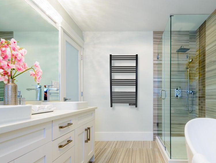 Helles Badezimmer mit Waschtisch, Spiegel, Dusche und Handtuchwärmer