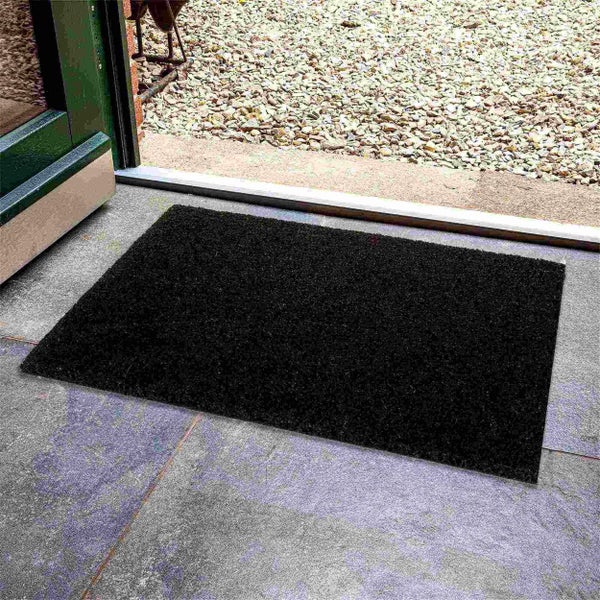 Schwarze Fußmatte mit den Maßen 60 mal 40 Zentimeter auf Holzgrund