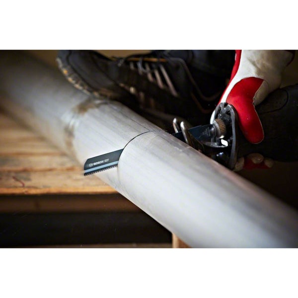 Person sägt Rohr mit einer Säbelsäge