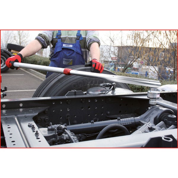 Eine Person bedient ein Richtwerkzeug an einem Fahrzeugrahmen.