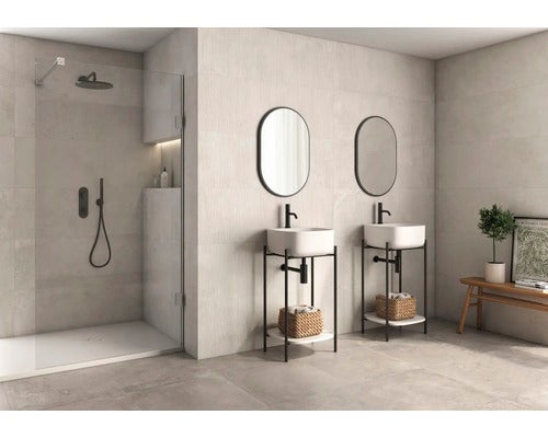 Helles Badezimmer mit Dusche, zwei Waschbecken mit Spiegeln und einer Holzbank