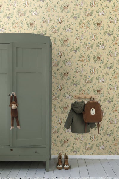 Vliestapete mit Waldtiermotiv in einem Kinderzimmer neben einem grünen Kleiderschrank und einer Wandgarderobe mit Kinderjacke und Bären-Rucksack.