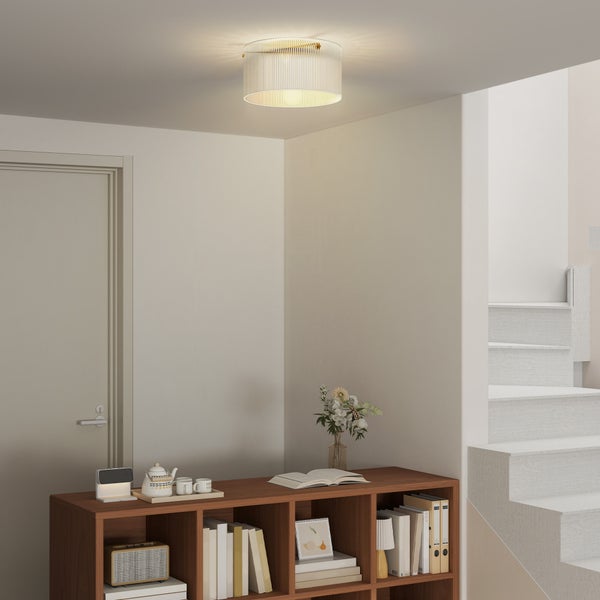 Deckenleuchte mit geriffeltem Glasschirm in einem hellen Raum über einem Holzregal und neben einer Treppe.
