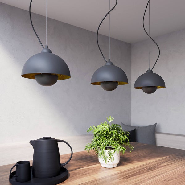 Esstischszene mit drei grauen Hängeleuchten, Teekanne, Tasse und Zimmerpflanze
