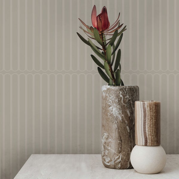 Dekoratives Stillleben mit einer Blume in einer Vase vor einer gestreiften Tapete