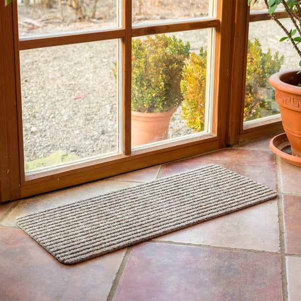 Fußmatte vor einer Tür auf Fliesenboden