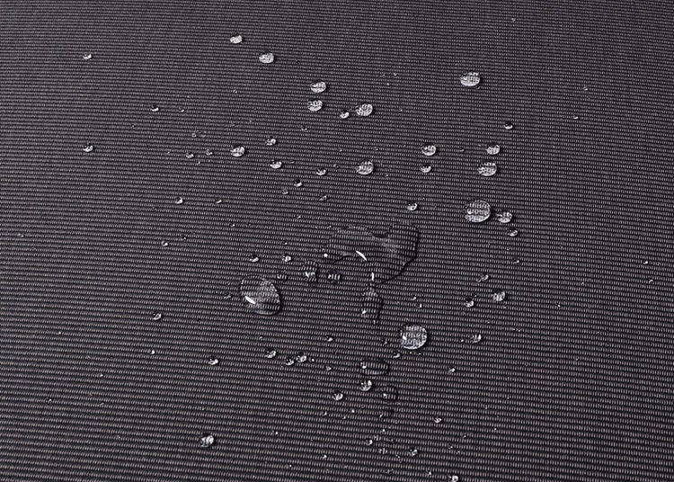 Wasserabweisendes Gewebe mit Wassertropfen auf der Oberfläche.