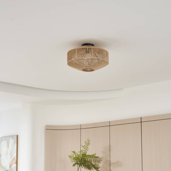 Deckenleuchte aus geflochtenem Material in runder bauchiger Form an einer Zimmerdecke.