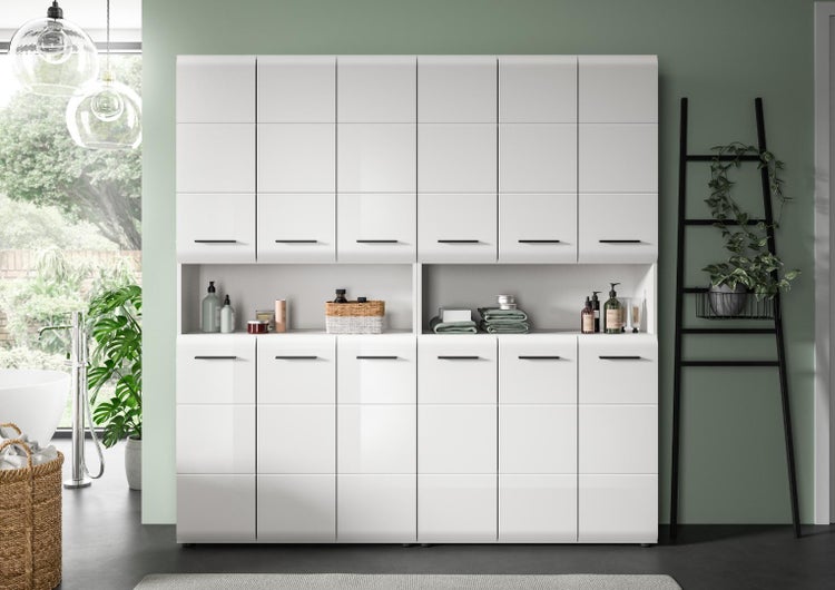 Modernes, weißes Hochglanz-Schranksystem im Büro mit schwarzen Griffen und offenem Fach für Bücher und Dekoration in hellem Arbeitszimmer.