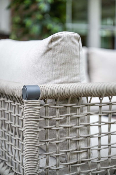 Detailansicht eines Gartenmöbels mit Seilgeflecht in Netzoptik und einem weichen Stoffkissen.